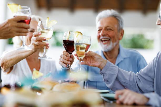 Close up of senior friends having fun while toasting with wine on a party.